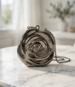 Silver gunmetal rose design chain clutch bag for women on marble surface