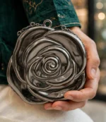 Silver metallic rose clutch bag held with emerald green party dress