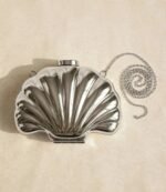 Silver metal shell clutch bag with detachable chain strap, flat lay view