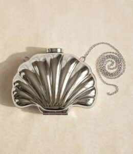 Silver metal shell clutch bag with detachable chain strap, flat lay view